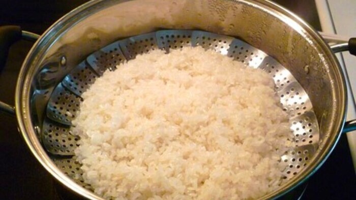 Cho gạo vào nồi để nấu xôi 